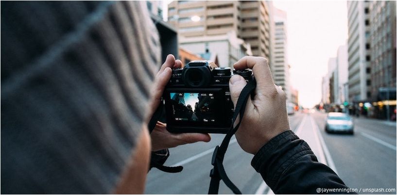 muž fotografuje ulicu mesta