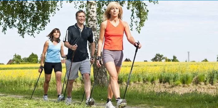 Ženy a muži sa venujú nordic walking.