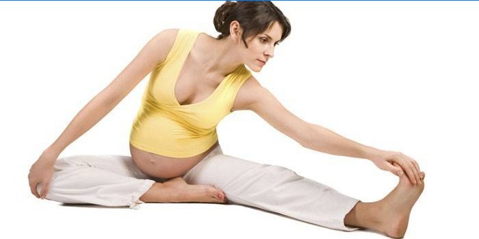 Tehotné dievča robí protahovacie cvičenia