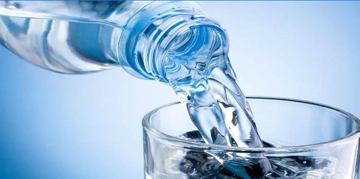 Voda z fľaše sa naleje do pohára