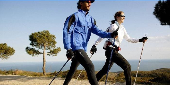 Muž a žena sa venujú nordic walking.